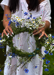 Fototapeta premium The girl holds a Kupala wreath in her hands.