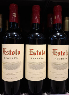 DENIA, SPAIN - July 04, 2025. Red wine bottles lined up on a supermarket shelf in Spain featuring a reserva variety from Convivio