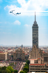 Naklejka premium Military aircraft flying over Torre Latinoamericana during Mexico Independence Day parade on September 16 in downtown Mexico City