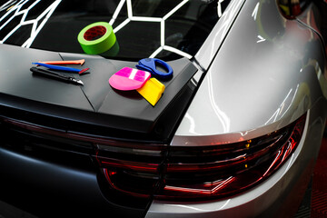 Set of Vinyl wrapping Tools on the car. Blades, scrapers, and squeegees enable smooth and accurate...