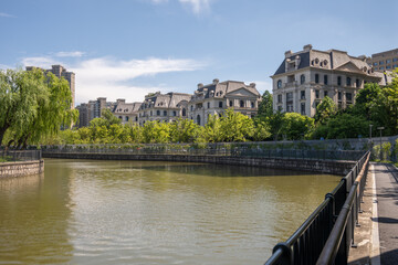 Water canal with European style architecture blends with modern skyscrapers. Evokes era of foreign...