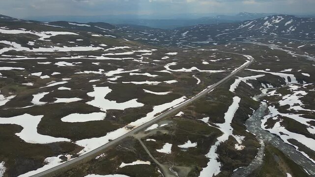 4K drone footage captures the vast tundra, lingering snow patches, and dramatic mountain scenery
