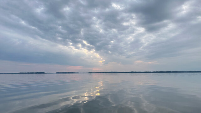 The sun is rising over Eastern Bay (Chesapeake Bay) behind clouds that are colored by the rays of the sun