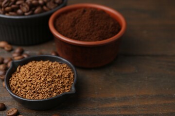 Different types of instant coffee and beans in bowls on wooden table, closeup