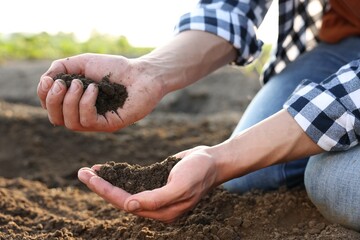 Man with pile of soil in field, closeup
