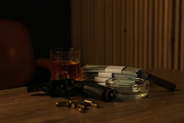 Gun, money, whiskey and other stuff on wooden table in mafia boss office