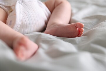 Cute newborn baby lying on bed, closeup