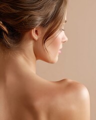 Fototapeta premium A white European woman shows her back and shoulders that receive soft light. Her skin is pink and smooth. The angle is calm and the composition is elegant. She uses clean beige tones.