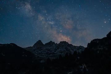 Starry Night Over Mountain Peaks: A dark silhouette of rugged mountains under a vast starlit sky Timeless beauty of nature
