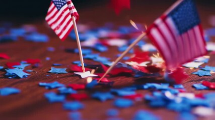 Patriotic American flags with red, white, and blue star confetti scattered on a wooden surface, symbolizing national celebration. - Powered by Adobe