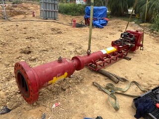 A red hot tapping machine placed on the ground at a pipeline worksite, ready for use in live...