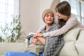Cancer patient receiving emotional support and care from loved family during chemotherapy recovery,...