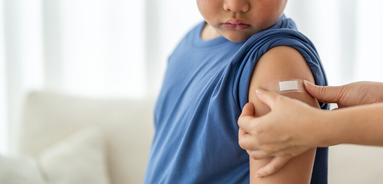Asian boy got vaccinated and receiving wound patch from medical doctor, showing child health pediatric vaccine, influenza and covid prevention immunity support, hospital care, healthcare safety - Powered by Adobe