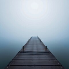 Obraz premium Serene wooden dock extending into a misty, tranquil water body.