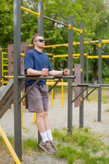 Obraz premium young man exercising on outdoor exercise equipment
