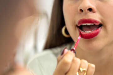 Woman applying red lipstick getting ready for night out
