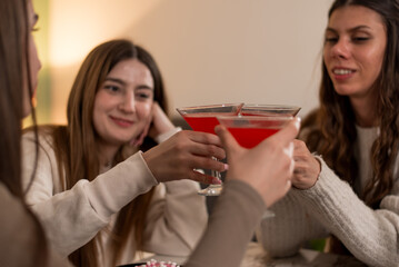 Group of friends enjoying red cocktails together in a cozy setting