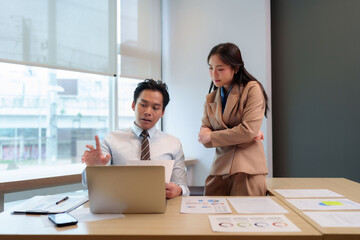 Asian adult business professionals discuss financial data report analysis corporate office meeting strategize plan