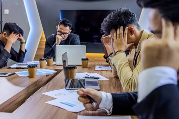 A Group of Businesspeople Looking Stressed Out While Working Together in an Office Meeting Room