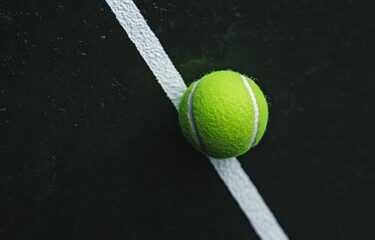 Tennis ball on dark court near line. (2)