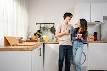 Asian young couple spend free leisure time together in kitchen at home.
