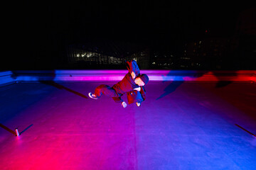 ビル屋上でアクロバティックなポーズを決めるダンサーの若者