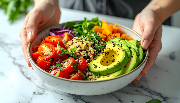 Hands present a vibrant, fresh salad bowl filled with colorful vegetables, quinoa, and sliced avocado, promoting healthy eating