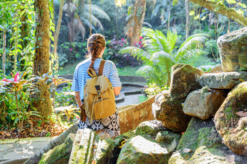Female tourist with backpack enjoying view of a tropical forest