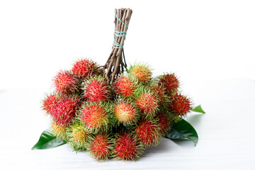 Fresh rambutan fruit on white wooden table.