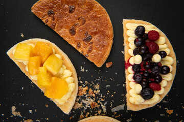 Delicious Fruit Tarts with Cream on a Black Surface
