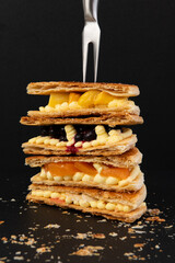 Delicious waffles with fruits on a black background, close-up