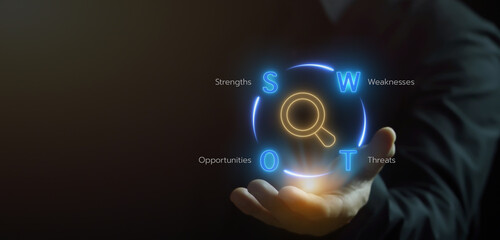 Strategic Planning concept is a process where organizations define their future vision, goals, and objectives, and outline how to achieve them. Businessman shows SWOT analysis icon on virtual screen.