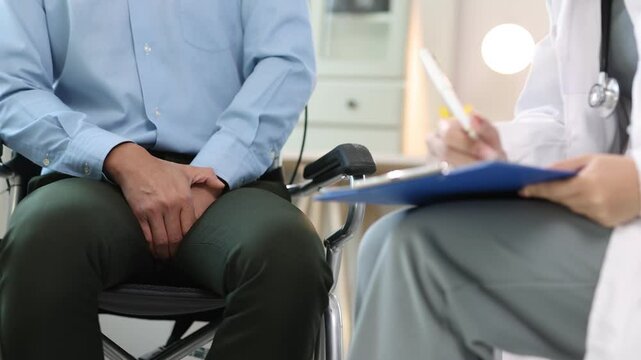 Professional medical consultation featuring male patient in wheelchair discussing groin discomfort and erectile dysfunction.