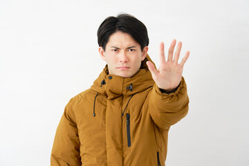 ダウンジャケットを着た男性　制止のポーズ　白背景