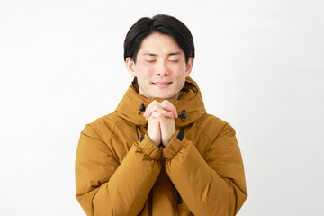 ダウンジャケットを着た男性　祈る　白背景