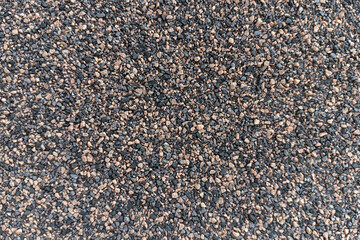 irregularly shaped gravel and pebbles in dark and light tones, creating a rough, granular texture.