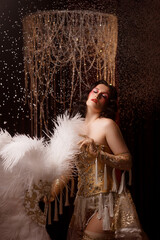 Young Caucasian circus performer or burlesque dancer in golden vintage corset, front view, posing...