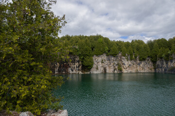 Elora quarry - the place with forest, rocks and amazing blue clear water. Popular place for activity - swimming, hiking and fishing on river. sunny summer day without people. Elora, Ontario, Canada