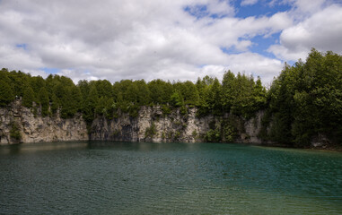 Elora quarry - the place with forest, rocks and amazing blue clear water. Popular place for activity - swimming, hiking and fishing on river. sunny summer day without people. Elora, Ontario, Canada