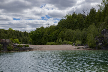Elora quarry - the place with forest, rocks and amazing blue clear water. Popular place for activity - swimming, hiking and fishing on river. sunny summer day without people. Elora, Ontario, Canada