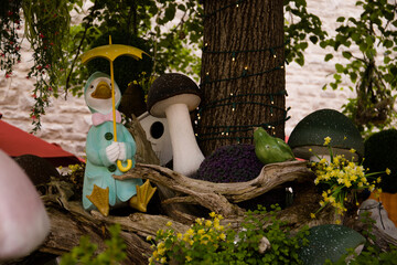 Garden decoration with mushrooms, cute birds and a flowers in the garden.
Fairy tale figures in the garden. Cute and funny characters.