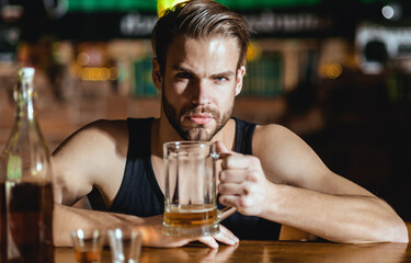 Man sitting alone in pub. Man with alcohol. Sad guy in bar. Guy in dark bar. Alcohol problem. Lonely man drinking whiskey at restaurant. Depressed man with glass of beer. Nightlife club.