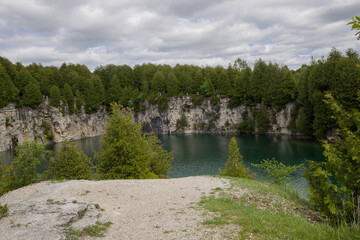 Elora quarry - the place with forest, rocks and amazing blue clear water. Popular place for activity - swimming, hiking and fishing on river. sunny summer day without people. Elora, Ontario, Canada