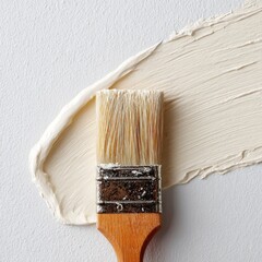 Paint brush stroke of cream-colored paint on light gray background