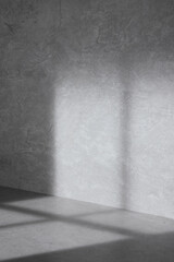 Concrete background that can be used in various designs with shadows of sunlight through the window.