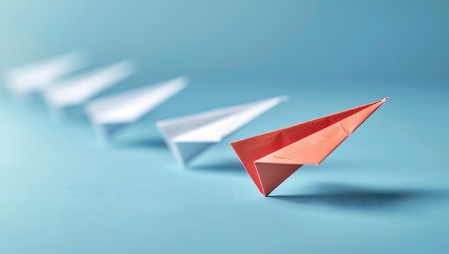 An image of red and white paper planes against a blue background, used for teamwork, leadership concepts, and corporate culture promotion.
