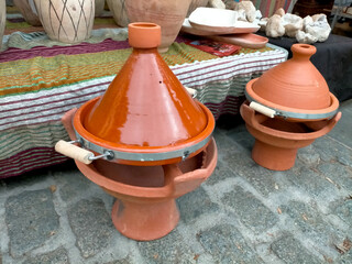 clay pots on the wal
The image shows a tagine, a baked clay container used in Maghrebi cuisine,...