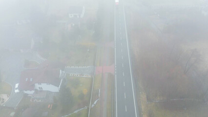 Car driving along misty highway overhead view