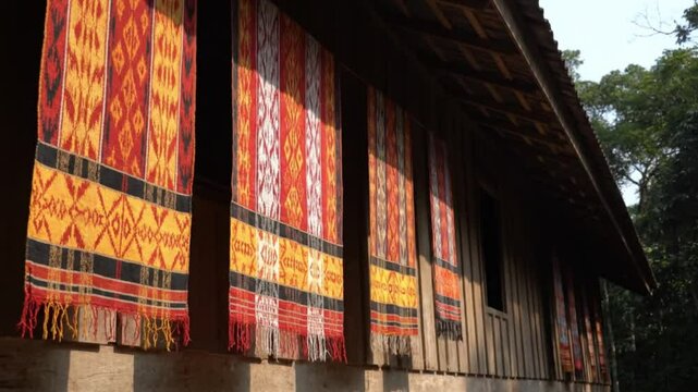 Dayak tribal woven cloths hanging to dry outside a traditional longhouse in Borneo.