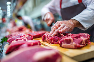Butcher preparing fresh meat at a market counter